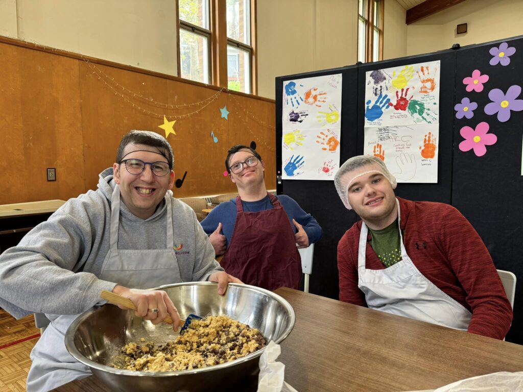 small group of participants smiling while preparing food together