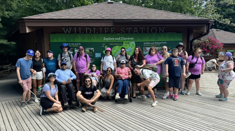 large group photo of summer camp participants gathered together in front of a pavilion map