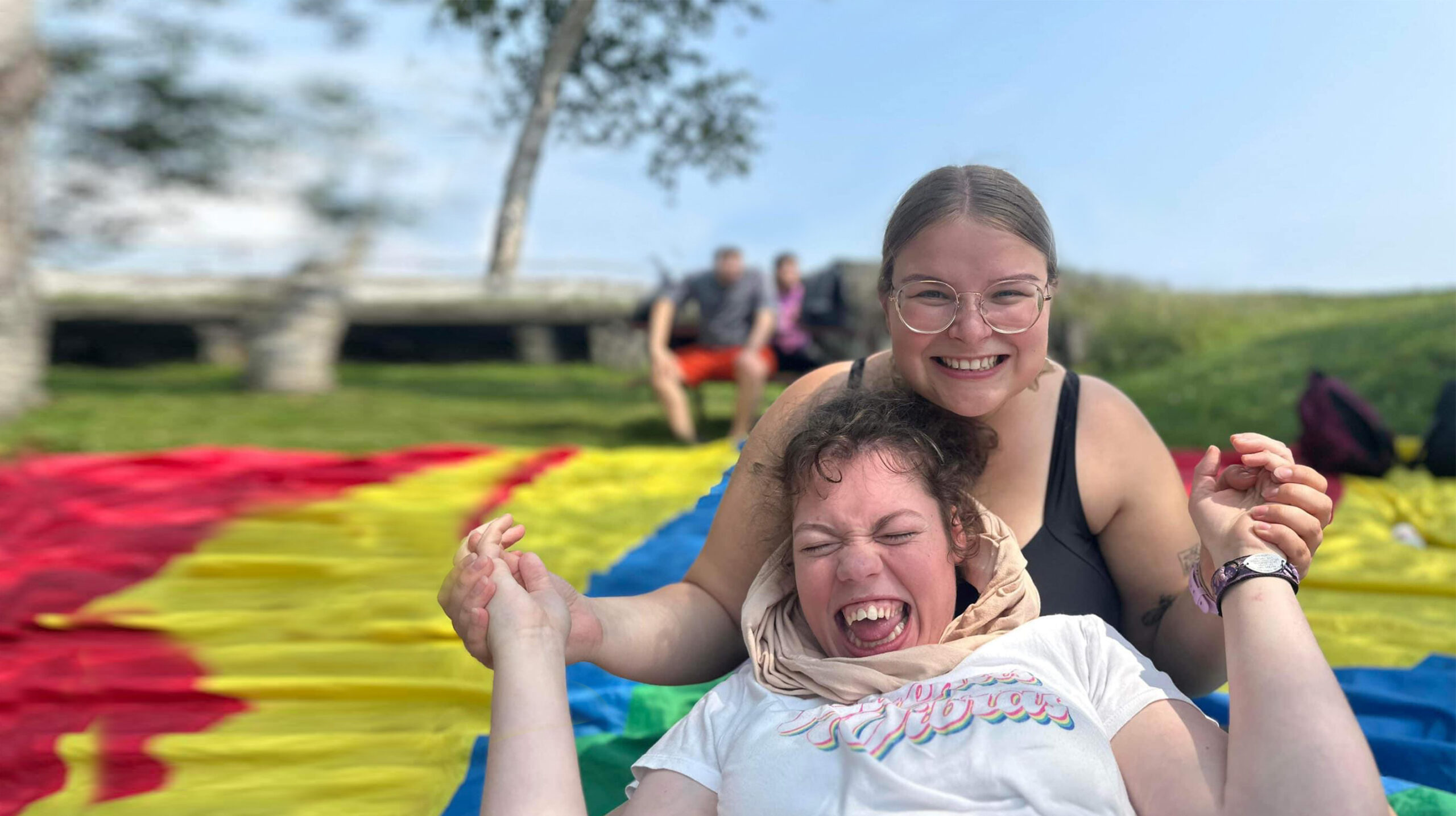 Two friends laughing and enjoying a sunny day outdoors, participating in fun activities