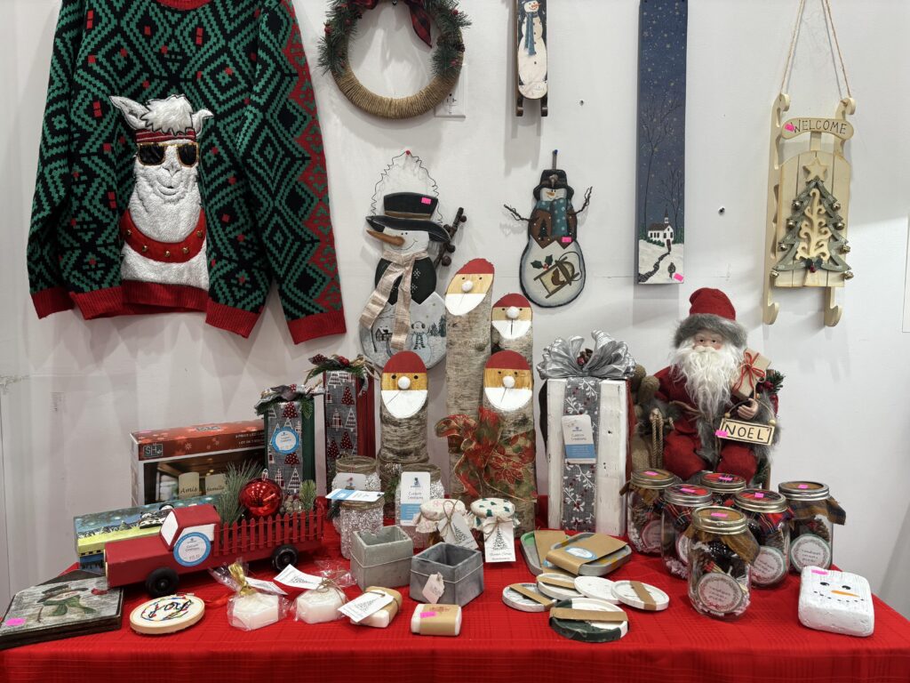table and wall display of craft and upcycled items at a pop-up market. 