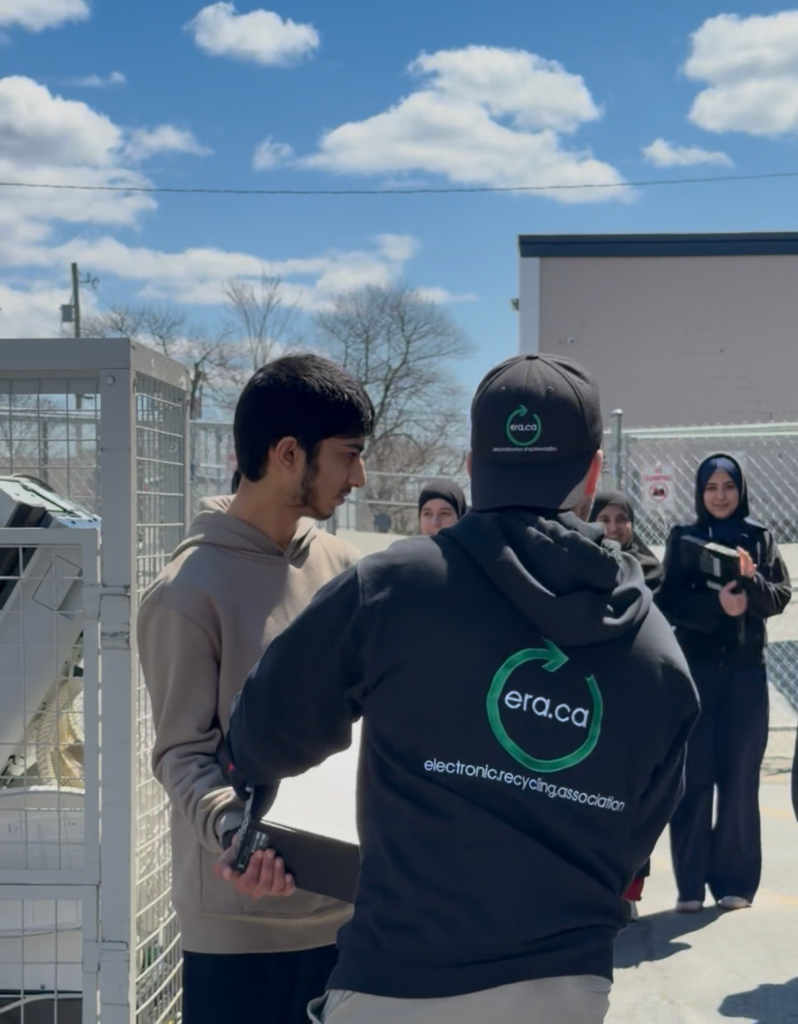 team members are outside on a sunny day collecting electronics from community members to recycle. 