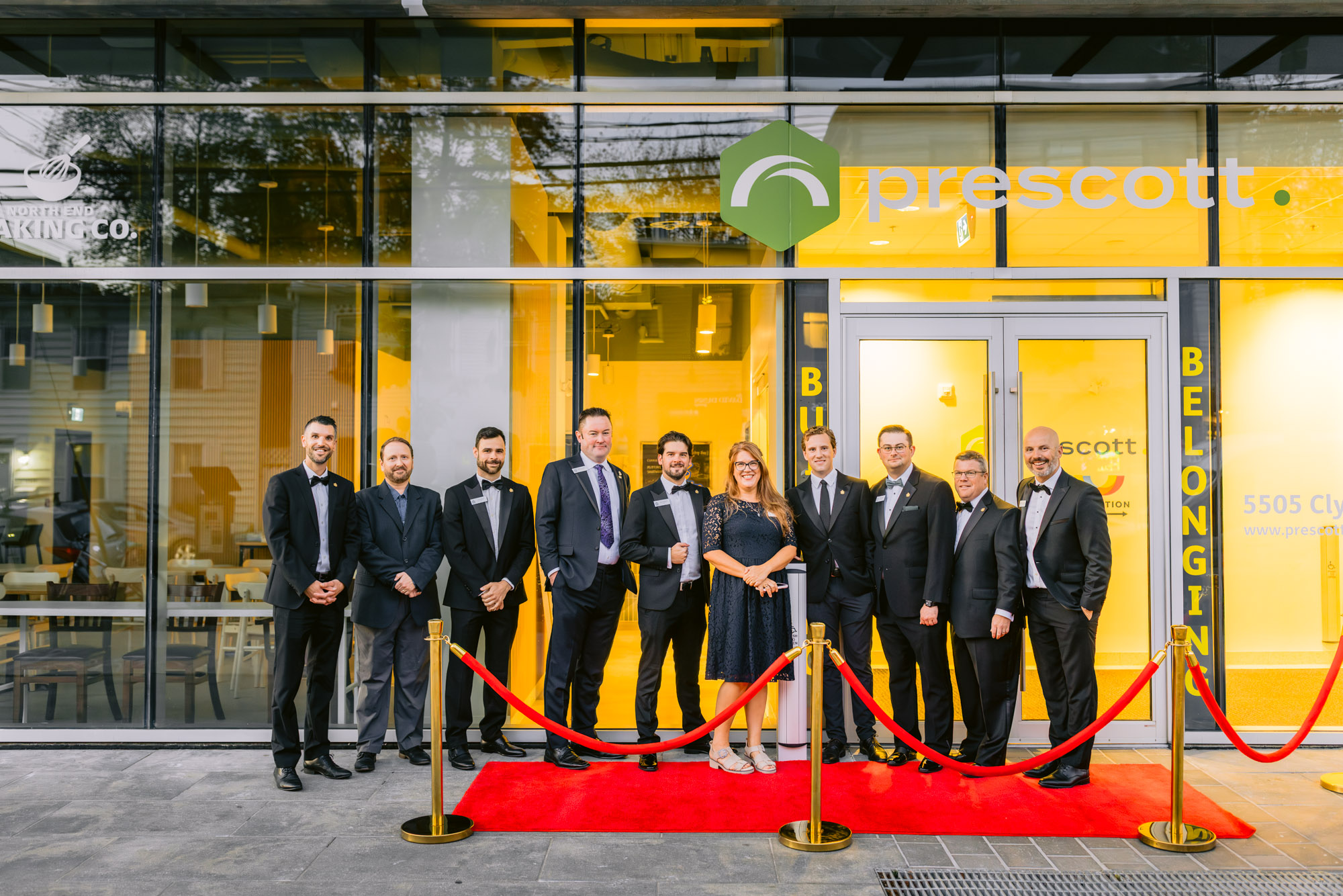 group of people stand on the right carpet, smiling at the grand opening on Progress Place