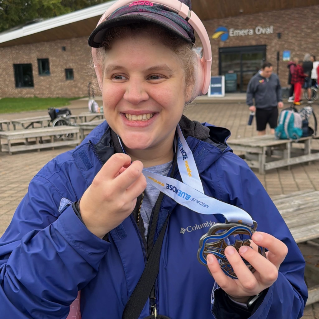 participant smiles while holding medal received for participating in walk-a-thon 2026